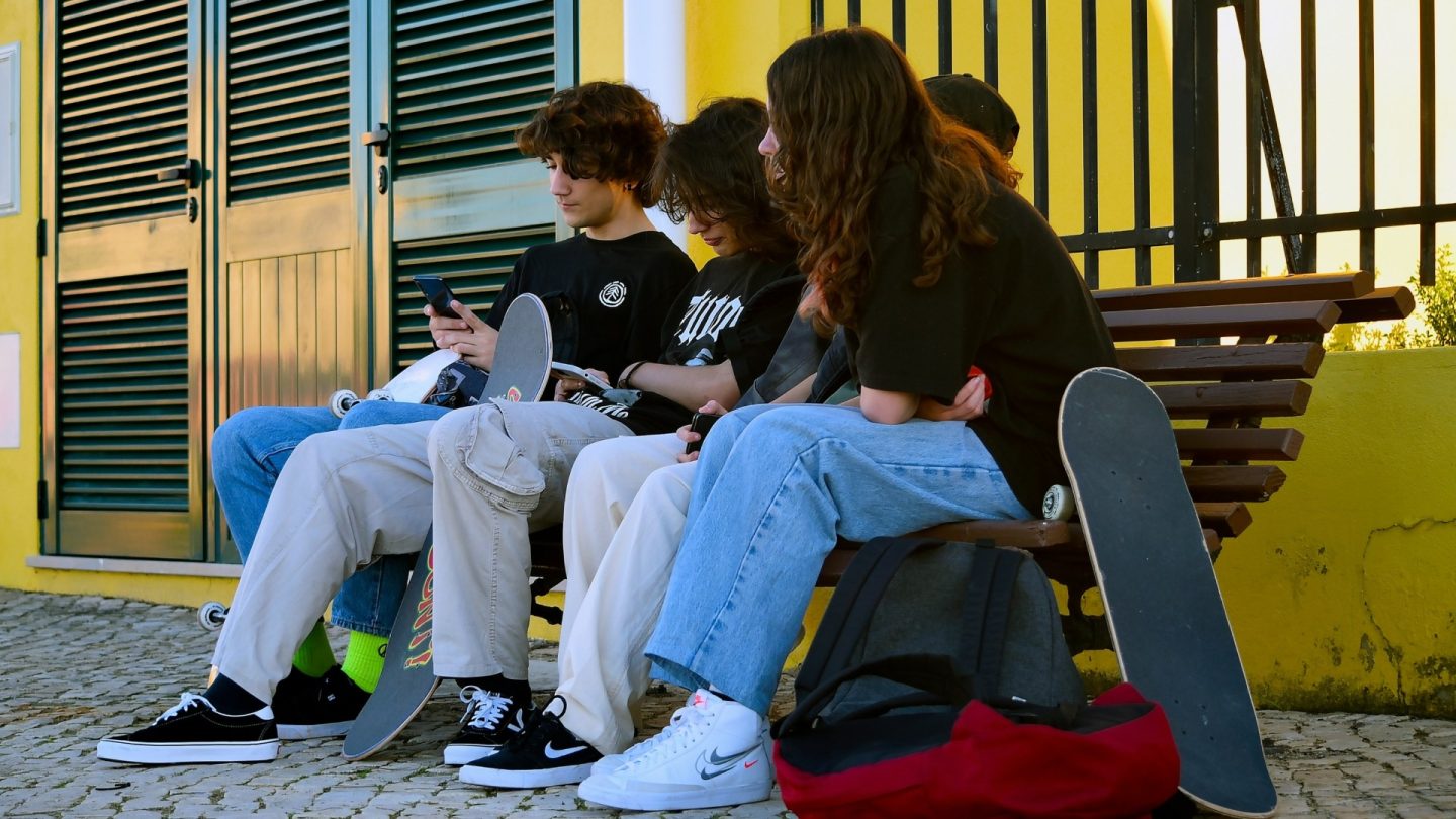 Εικόνα που απεικονίζει παιδιά να χρησιμοποιούν κινητά τηλέφωνα.